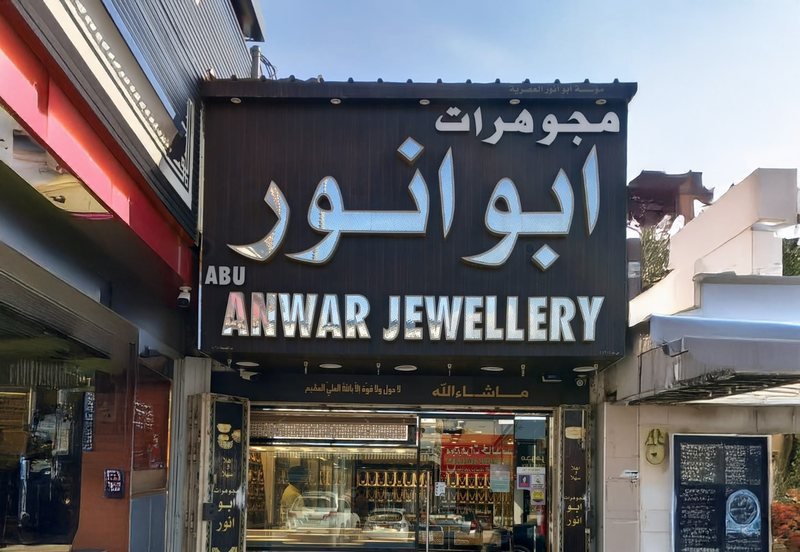 The shop front of Abu Anwar Jewellery, with its sign in Arabic and English above a display window of jewellery